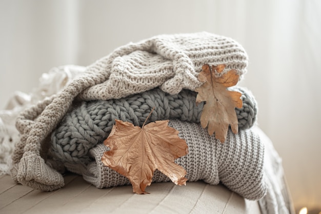 Close-up of a stack of knitted sweaters on a blurred background.