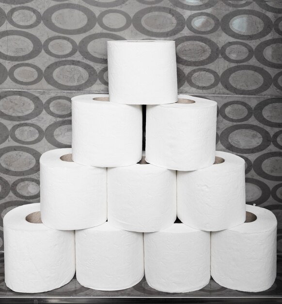 Close-up stack of toilet paper rolls on shelf