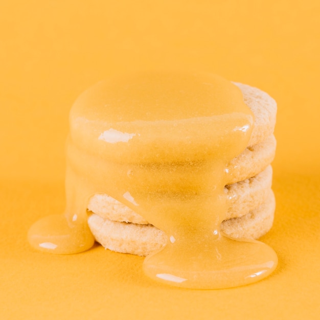 Free photo close-up of stacked cookies with lemon curd on yellow backdrop