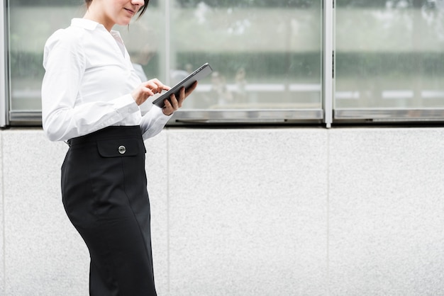 タブレットでクローズアップ立っている女性