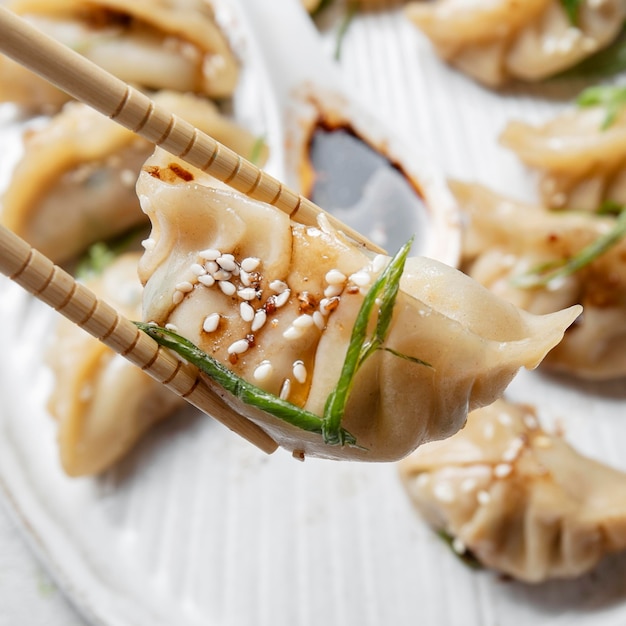 Foto gratuita bastoni del primo piano che tengono alimento asiatico