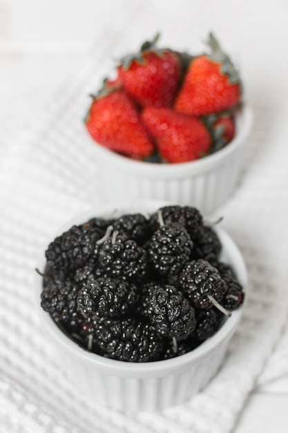 Free photo close-up of strawberries and mulberries in bowls