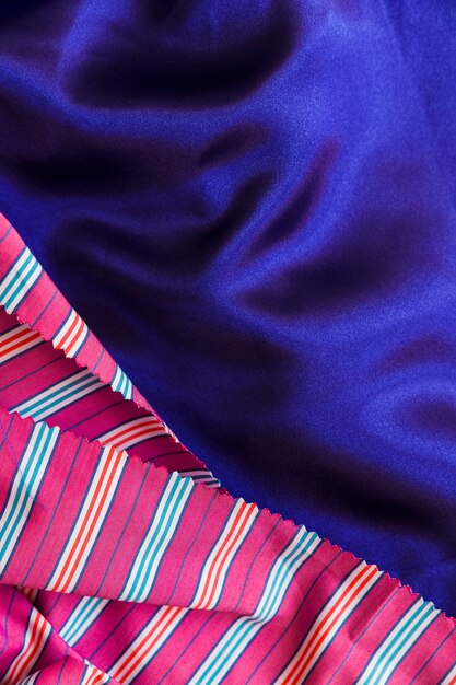 Close-up of stripes pattern textile on smooth blue cloth