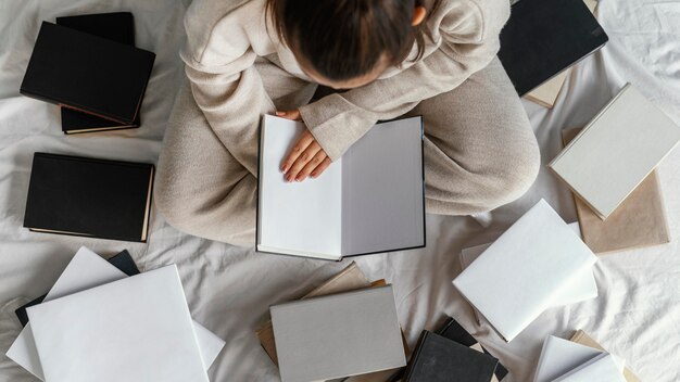 Foto gratuita chiuda in su studente a letto con vista dall'alto di libri