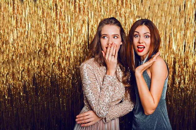 Close up studio image of two amazing sexy celebrating girls  with red lips, surprise face,