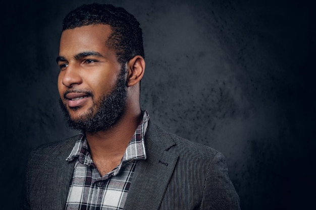 Close up studio portrait of Black bearded male over grey background.