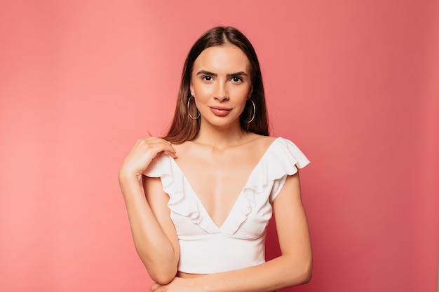 Close up studio portrait of stylish beautiful woman posing over isolated pink wall