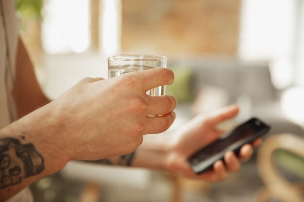 Close up of stylish caucasian man using smartphone, taking selfie. Surfing, online shopping, scrolling, betting, working. Education, freelance, art and business concept. Coffee drinking.