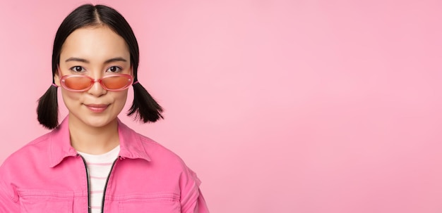 핑크색 배경 사람들 fa에 대 한 행복 한 포즈를 웃 고 선글라스에 세련 된 한국 여자의 클로즈업