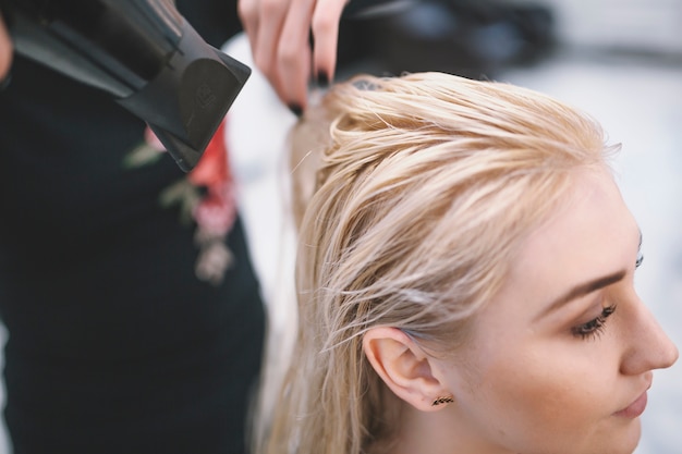 Close-up of stylist drying wet hair