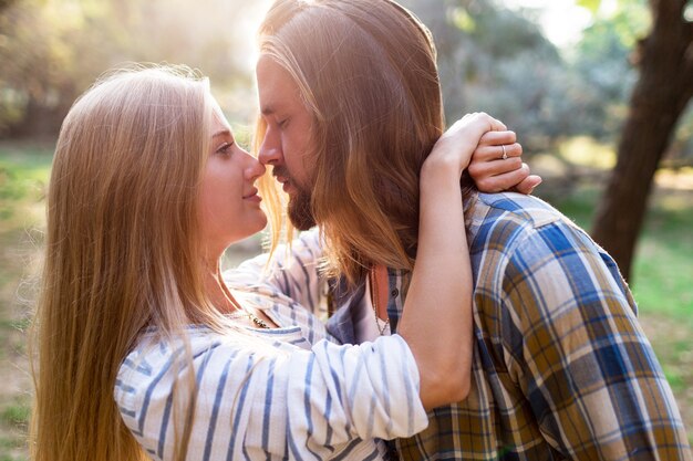 Close up summer warm romantic portrait of two people, couple in love kissing and hugging.