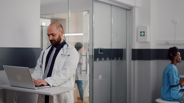 Close up of surgeon doctor wearing medical uniform typing recovery treatment