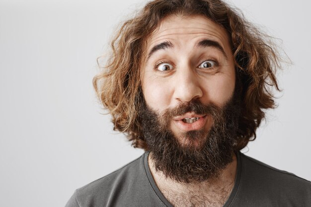 Close-up of surprised upbeat middle-eastern man looking fascinated