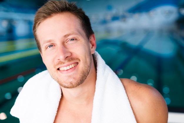 Close-up swimmer posing with towel on his shoulders