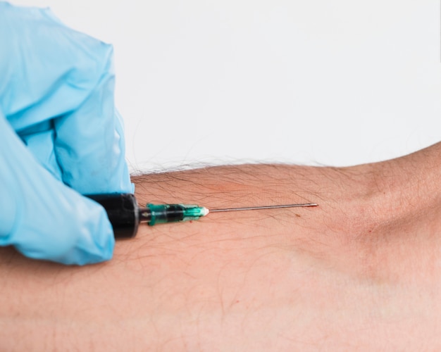 Close-up syringe taking blood from vein