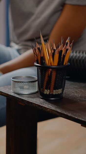 Close up of table with art tools and colorful pencils for professional drawing concept in art studio space. African american creative artist working on masterpiece canvas for project