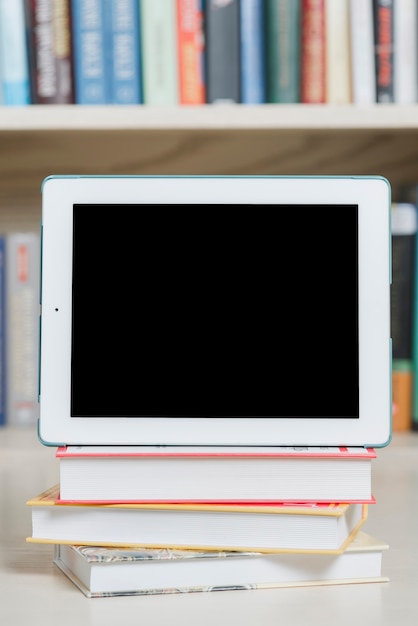Close-up tablet and books in library