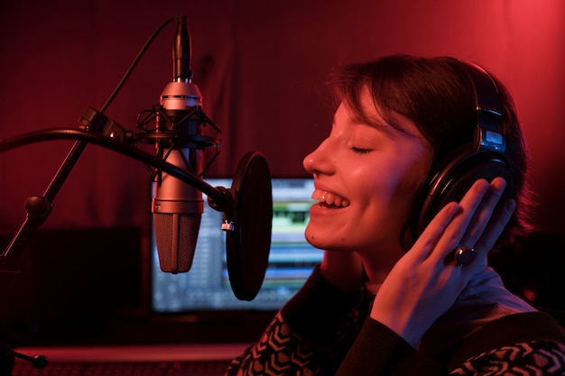 Close up talented woman singing at microphone