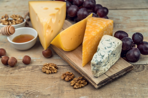 Close-up tasty assortment of cheese on the table with walnuts