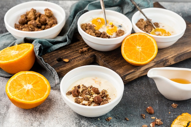 Close-up tasty breakfast bowls with granola and orange