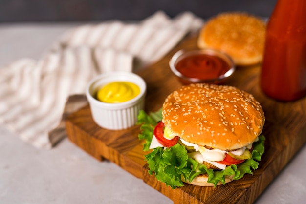 Крупным планом вкусные гамбургеры с горчицей и кетчупом