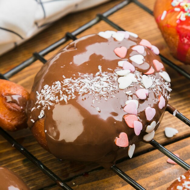 맛있는 초콜릿 도넛의 근접 카운터 위에 쟁반에 심장 모양 뿌리와 장식