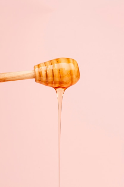 Close-up tasty honey pouring from stick