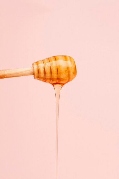 Close-up tasty honey pouring from stick