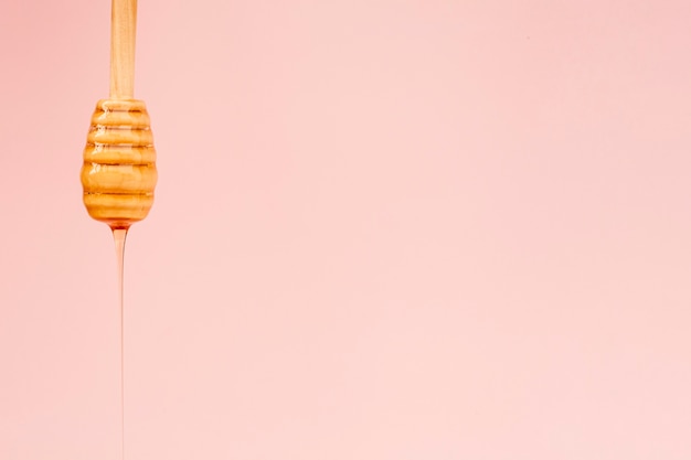 Close-up tasty honey pouring from a stick