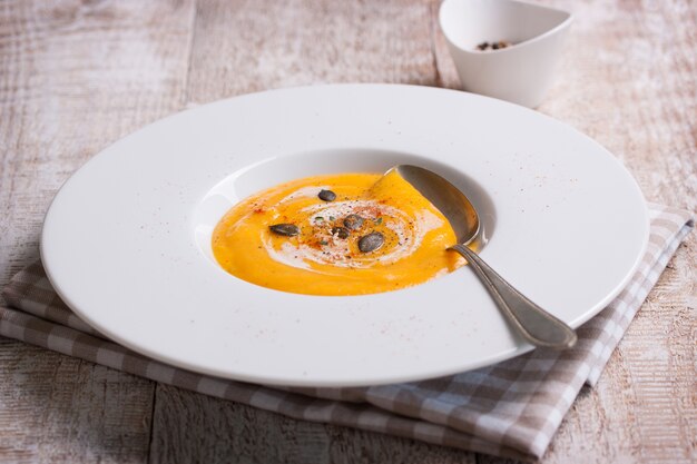 Close-up of tasty pumpkin soup with spoon