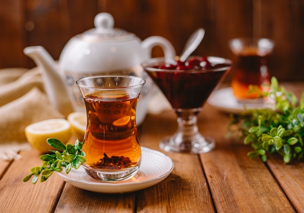 Close up of tea in armudu glass served with azerbaijani murabba and lemon