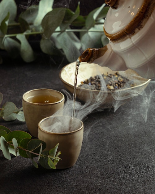 Foto gratuita tè di versamento della tazza da tè del primo piano