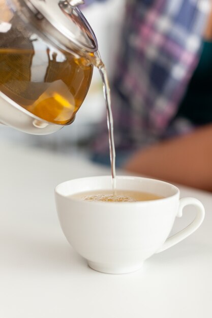 Закройте чайник с горячей водой для приготовления чая с зелеными травами
