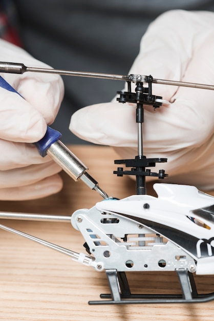 Free photo close-up of a technician hand repairing helicopter toy