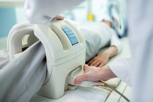 Close up of technician preparing a patient for knee MRI scan procedure at clinic