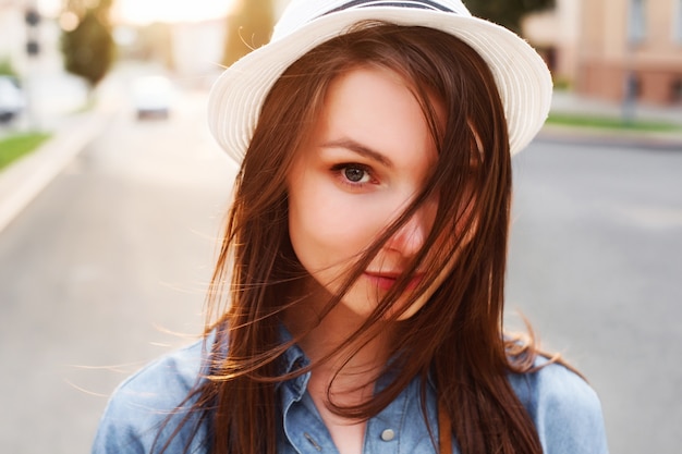 Primo piano di teen con cappello bianco e camicia di jeans