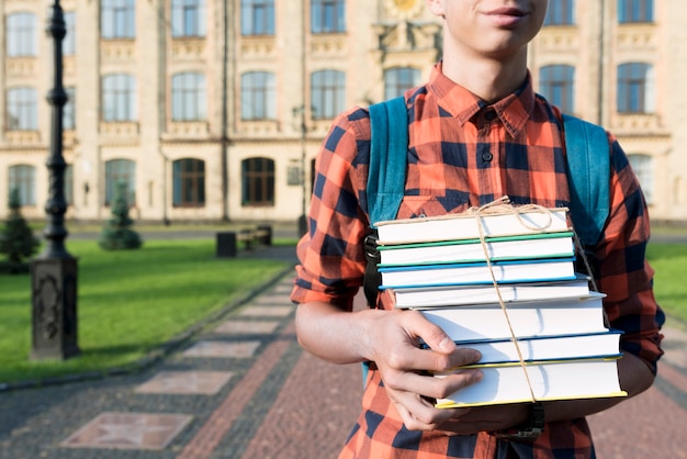 Close up of teenage boy holding books