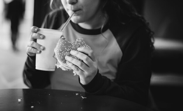 Close up of teenage girl eating hamburger