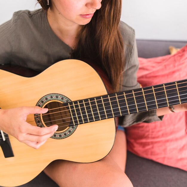 Close-up of a teenage girl playing guitar