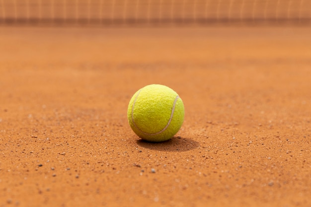 Foto gratuita pallina da tennis del primo piano sulla terra del campo