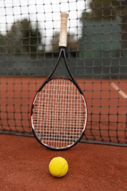 Foto gratuita primo piano su pallina da tennis e racchetta in cortile