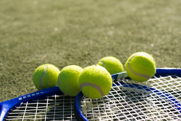 Бесплатное фото Крупные теннисные мячи с ракетками