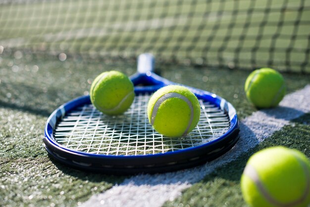 Крупный план теннисной ракетки и мячей
