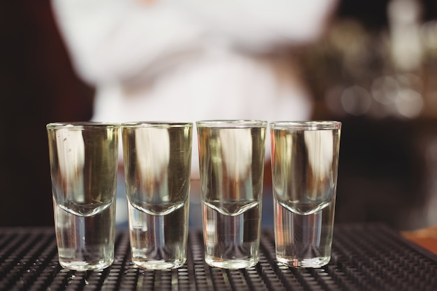 Close-up of tequila in shot glasses on bar counter