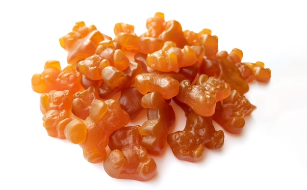 Текстура крупным планом оранжевых и желтых поливитаминных жевательных конфет в виде медведей на белом фоне. концепция здорового образа жизни.