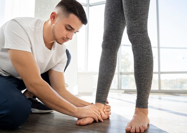 Close up therapist helping patient walk