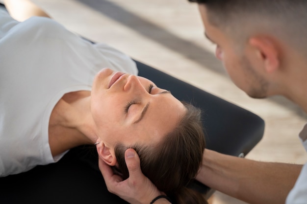 Free photo close up therapist holding patient's head