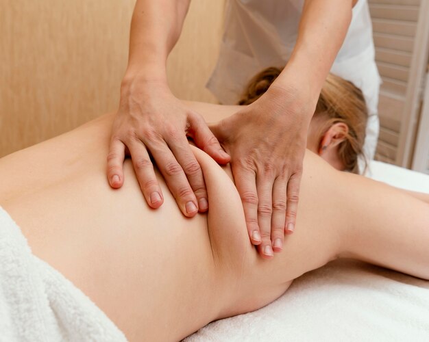 Close up therapist massaging woman's back