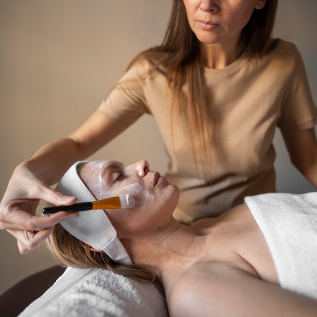 Close-up therapist putting on face mask