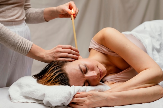 Close up therapist using candle in ear